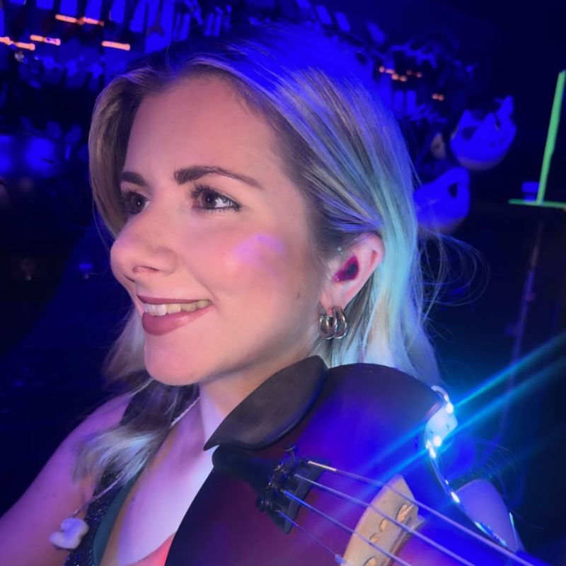 Lara Simpson playing the violin with her Cosmic Ears custom in-ear monitors in her ears